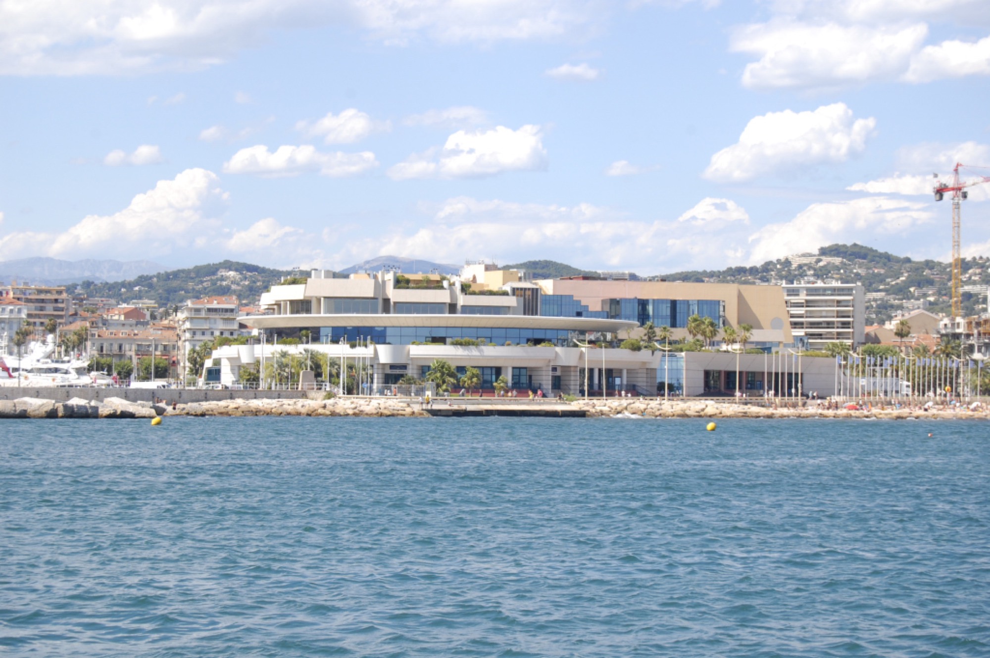 The Palais des Festivals et des Congrès in Cannes, which houses the casino, seen from the water with the hills behind