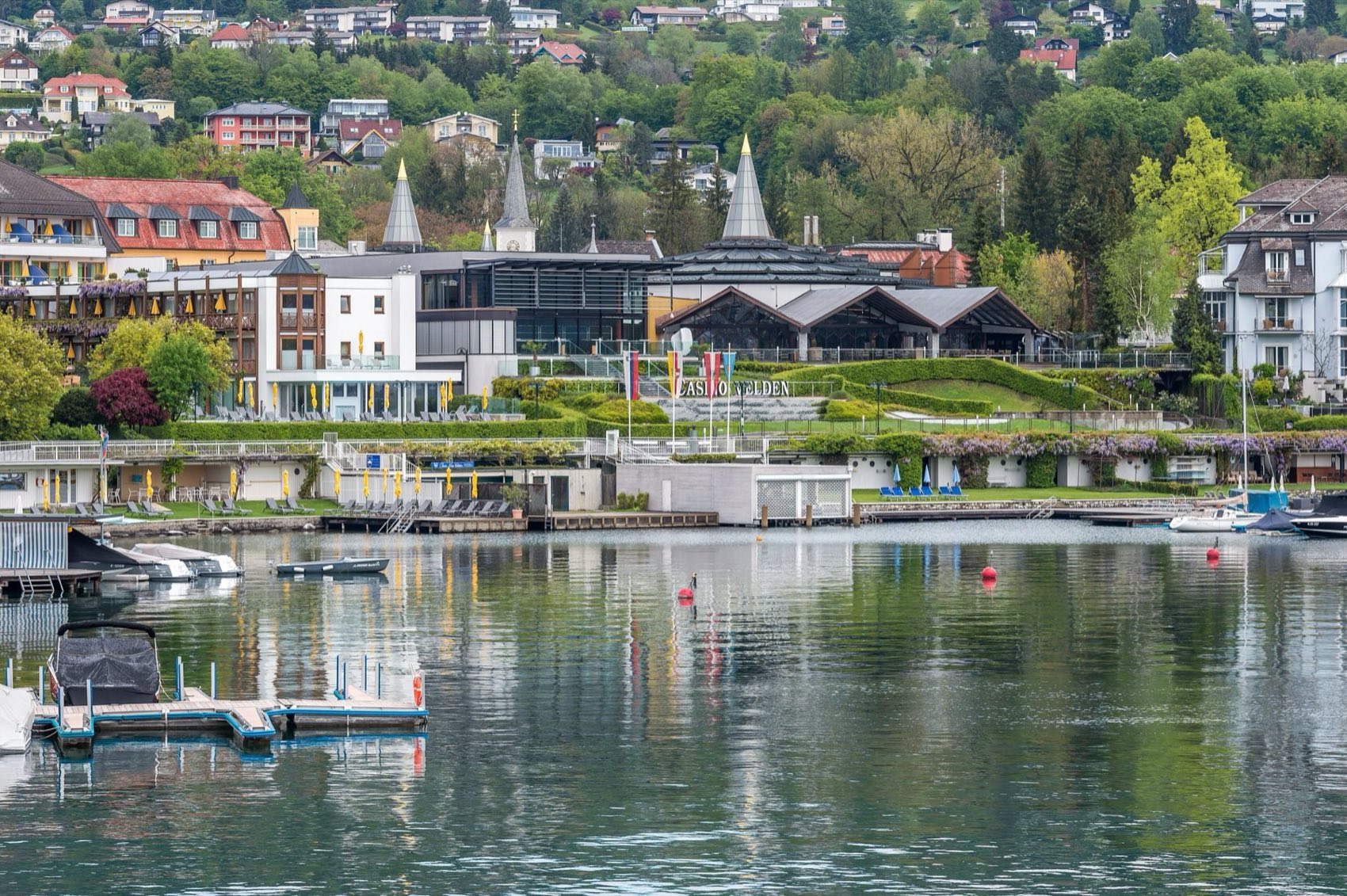Casino Velden on the shore of the Wörthersee, a modern building with pointed tent-like roofs seen across the lake with the town behind